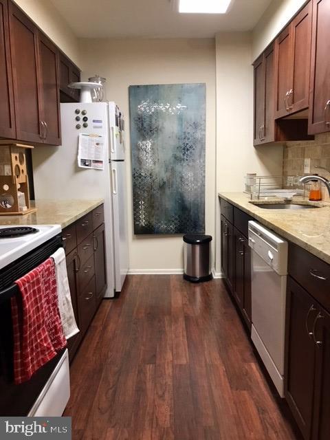 a kitchen with stainless steel appliances granite countertop a stove a sink dishwasher and a refrigerator with wooden floor