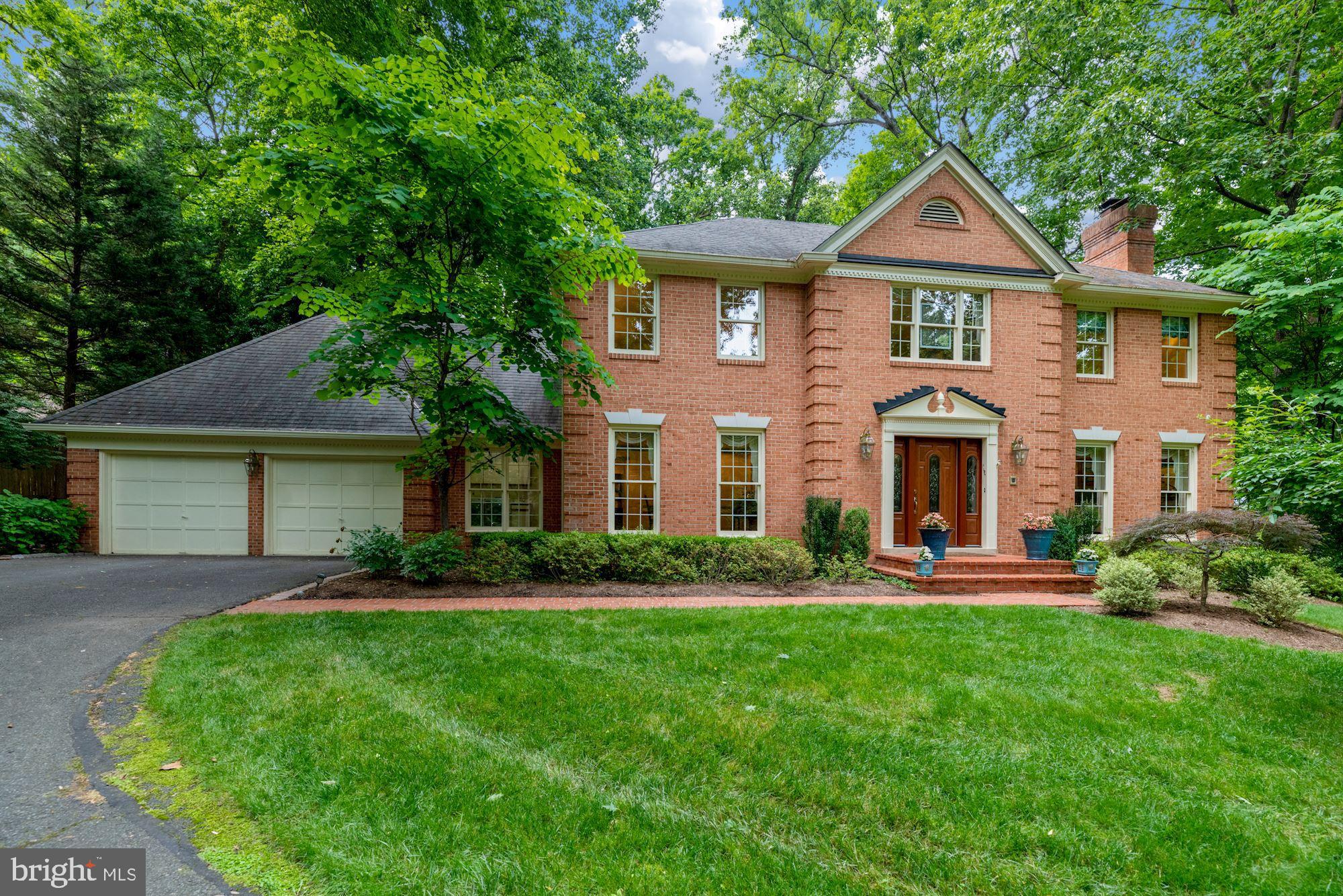 a front view of a house with a yard and green space