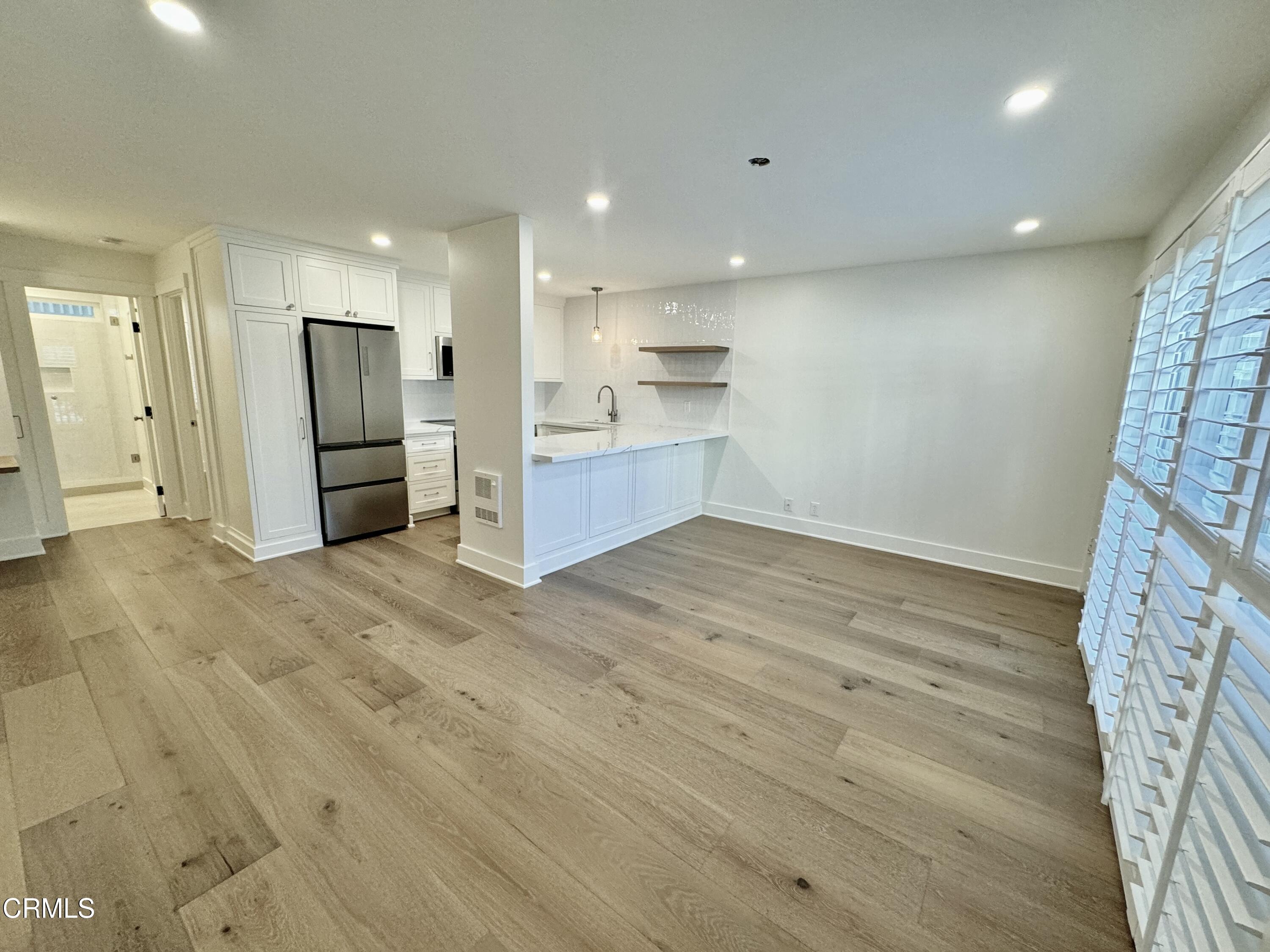 a view of kitchen with refrigerator and wooden floor