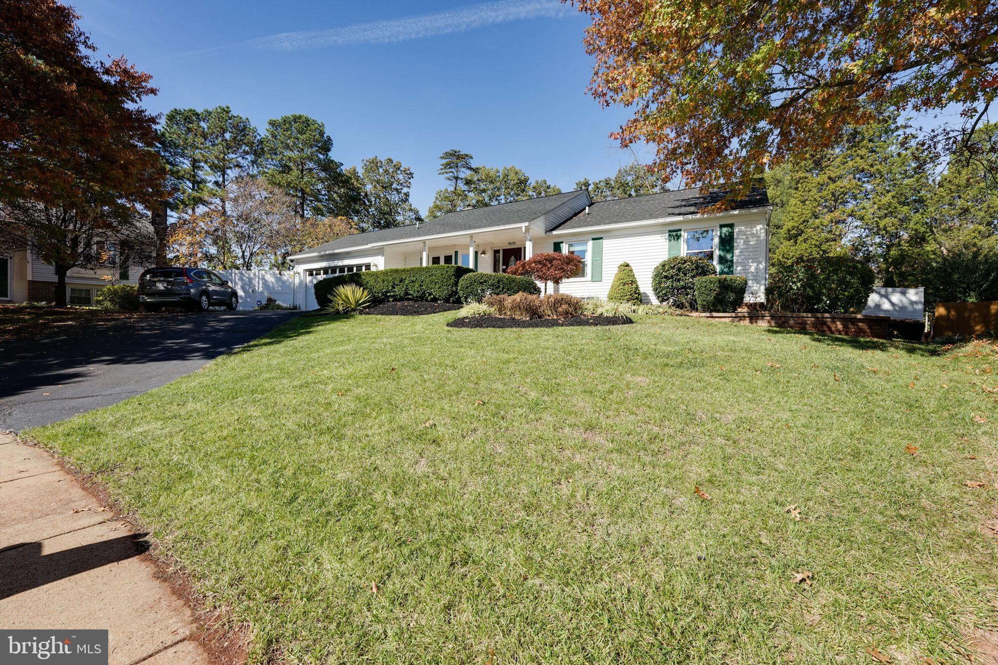 a front view of a house with a yard and trees