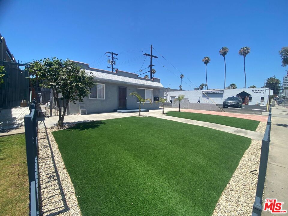 a view of a house with backyard and sitting area