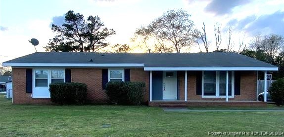 a view of a brick house with a yard and a large window