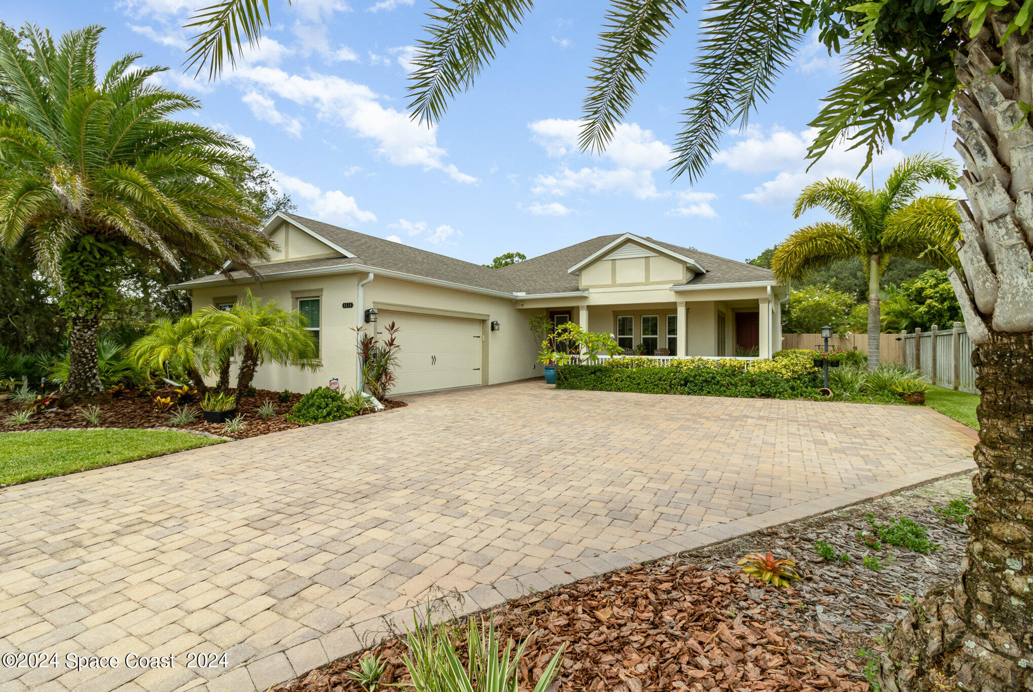 a view of a white house with a yard and palm trees