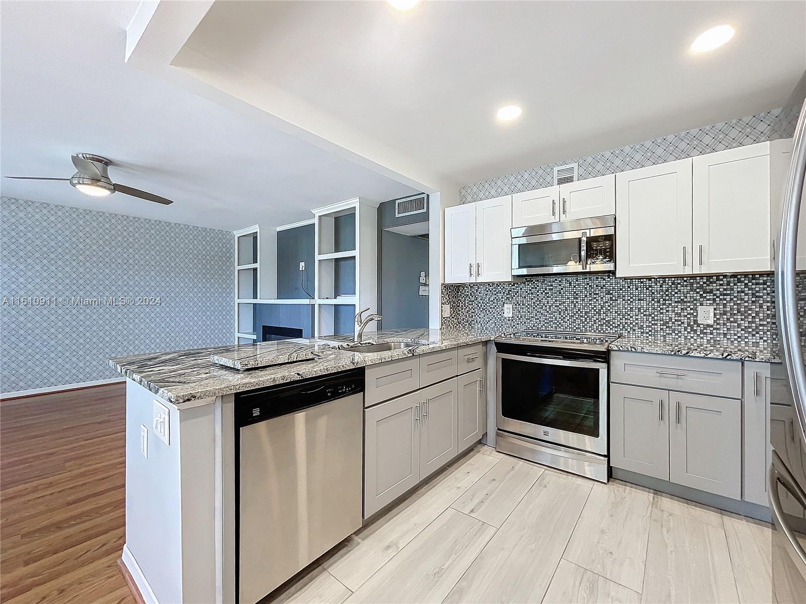 a kitchen with stainless steel appliances granite countertop a stove and a sink