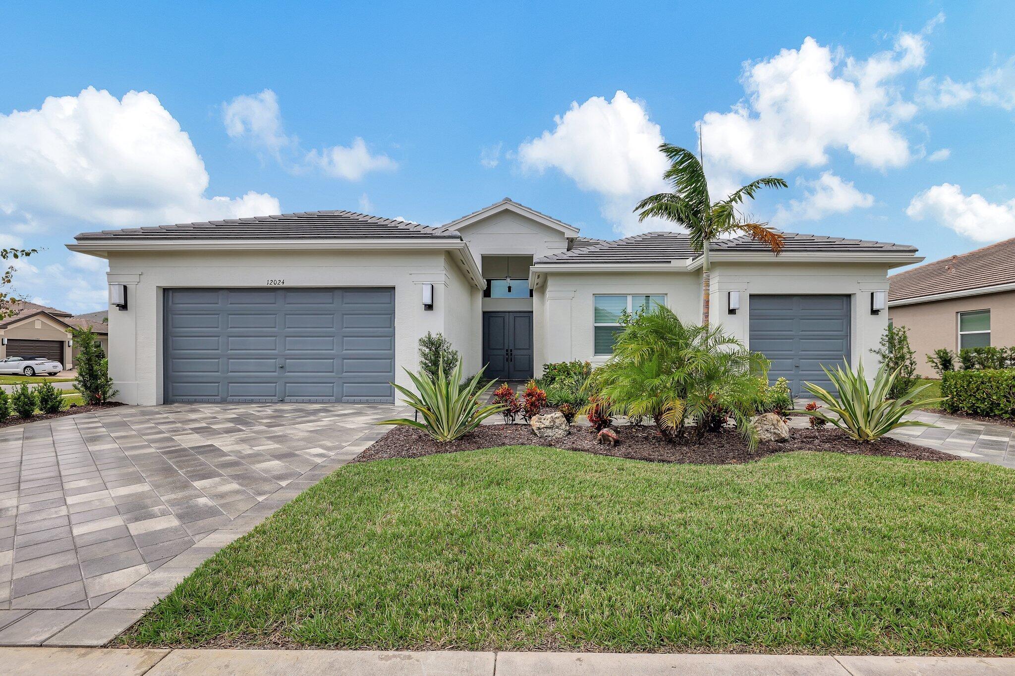 a front view of a house with a garden and yard