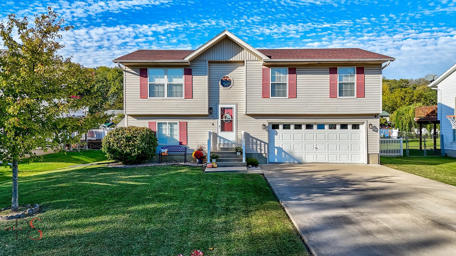 a front view of a house with a yard and trees