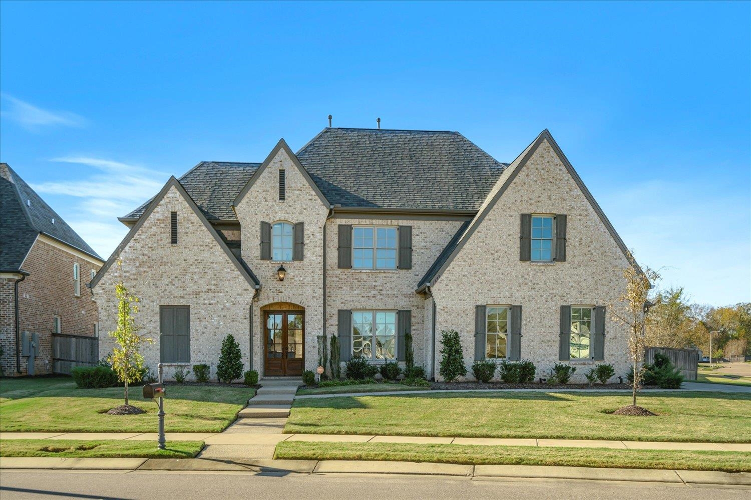 View of front facade featuring french doors and a front lawn