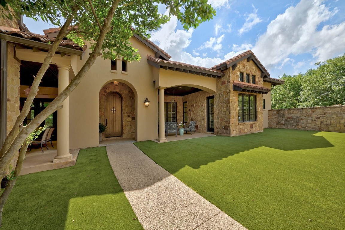 a view of a big house with a big yard and large tree