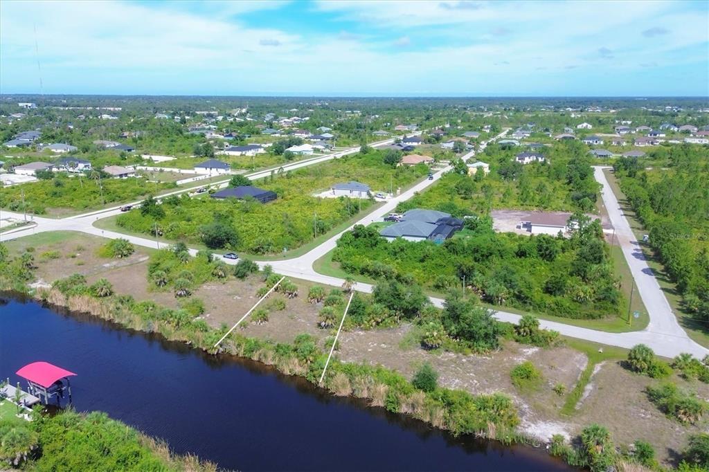 an aerial view of residential houses with outdoor space and trees