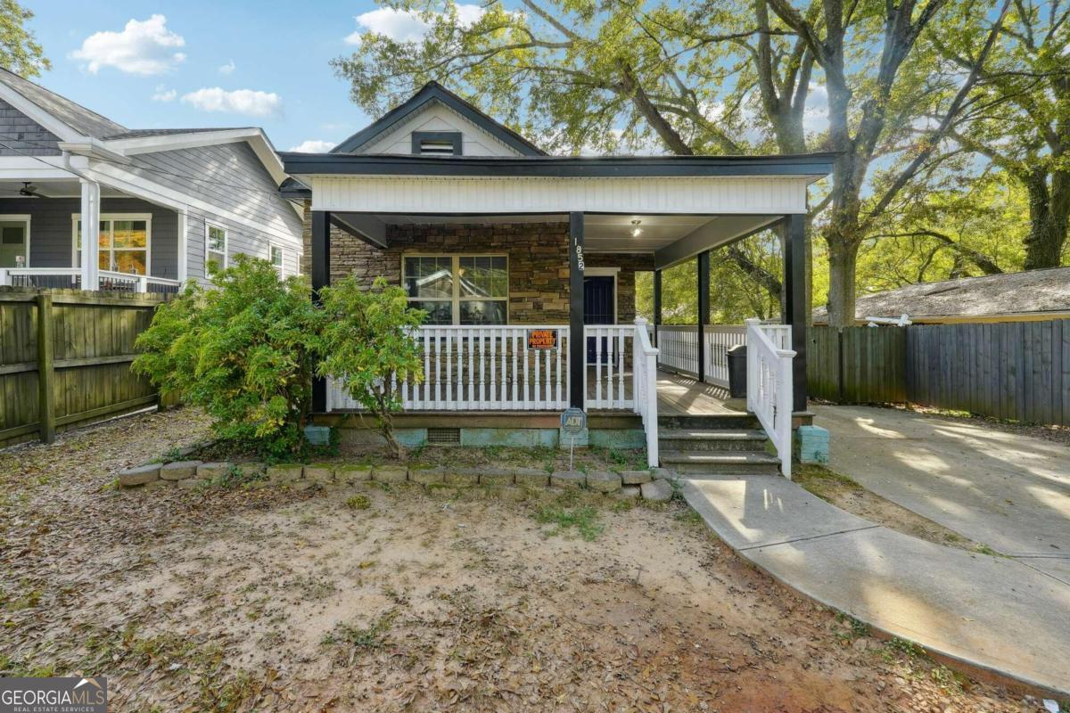 a view of a house with a yard and wooden fence