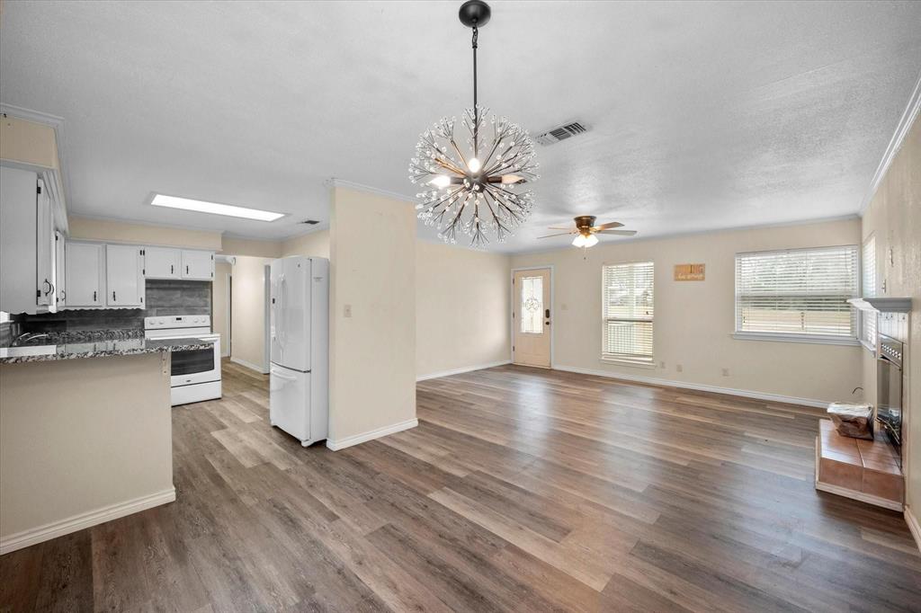 a view of a kitchen with stove and wooden floor