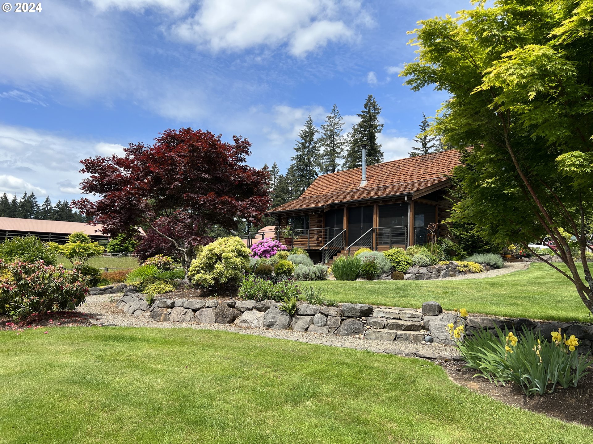 a front view of a house with a yard and potted plants