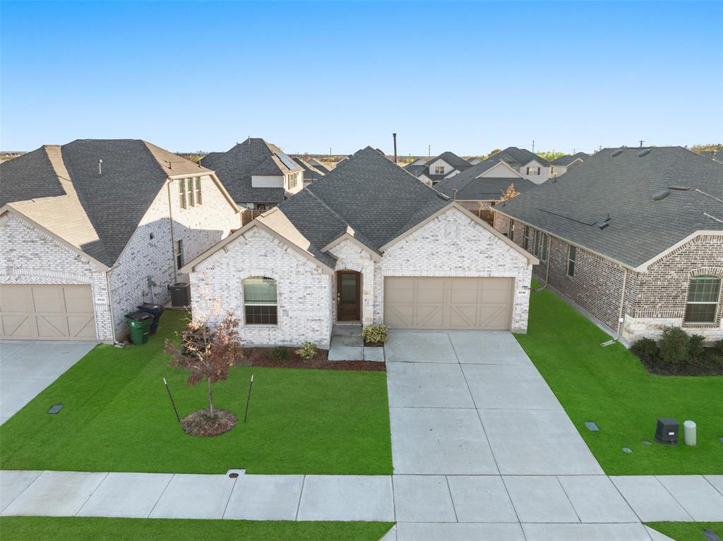 View of front facade featuring a front yard and a garage