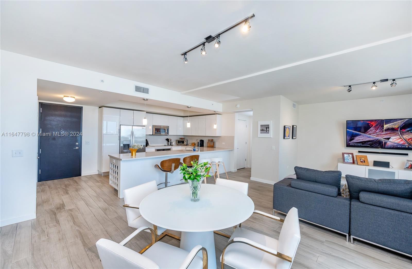 a living room with furniture and a dining table with wooden floor