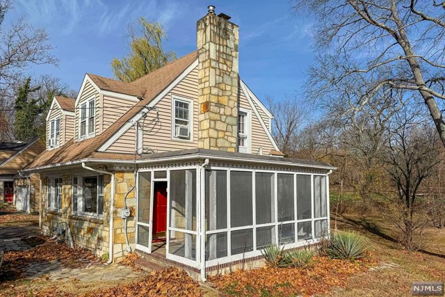 a view of small white house with large windows and a small yard