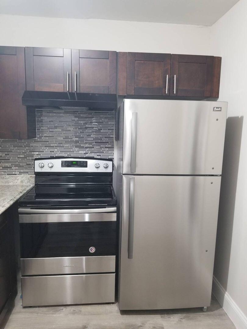 a view of a kitchen with wooden floor and electronic appliances