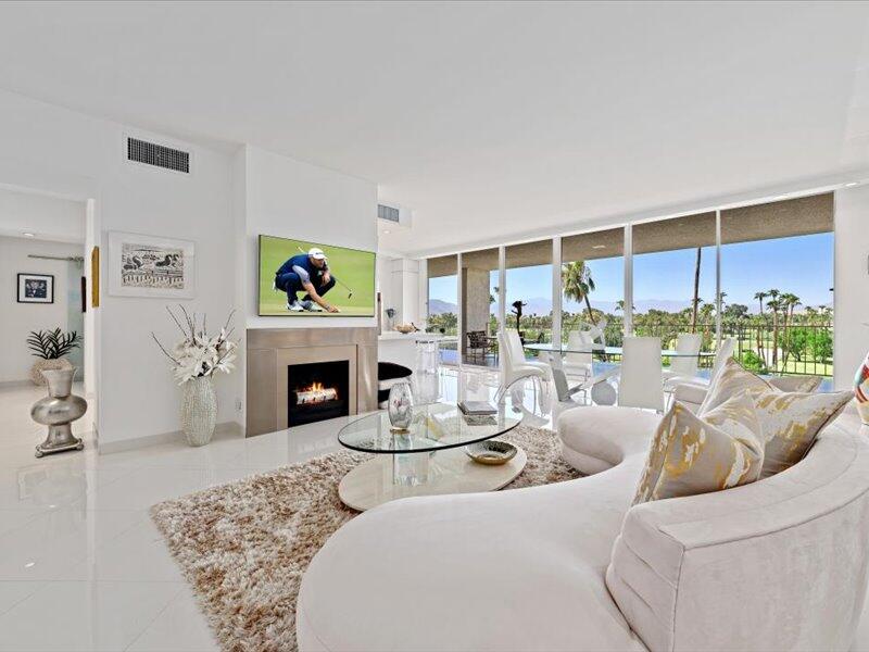 a living room with furniture a fireplace and a floor to ceiling window