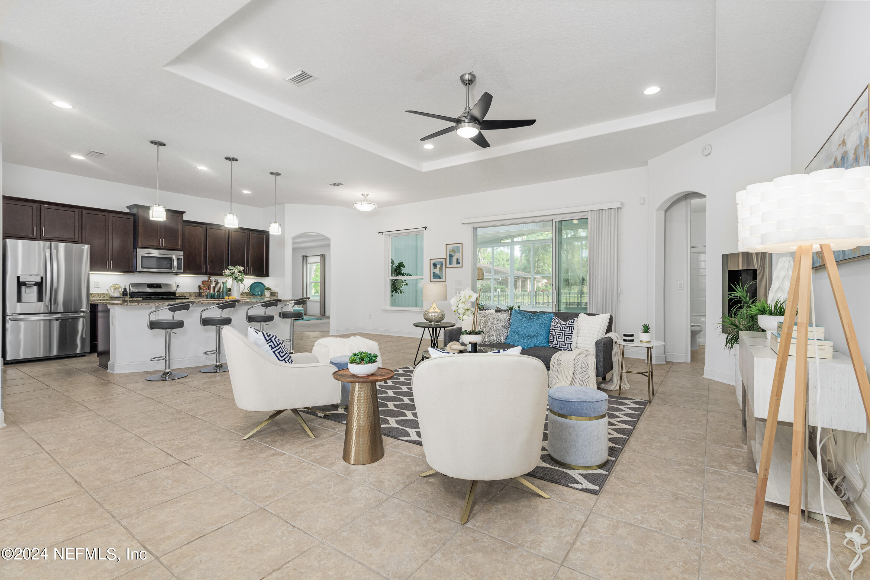 a living room with lots of furniture and view of kitchen