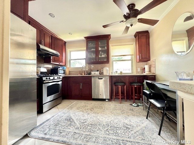 a kitchen with stainless steel appliances kitchen island granite countertop a stove top oven a sink a dining table and chairs