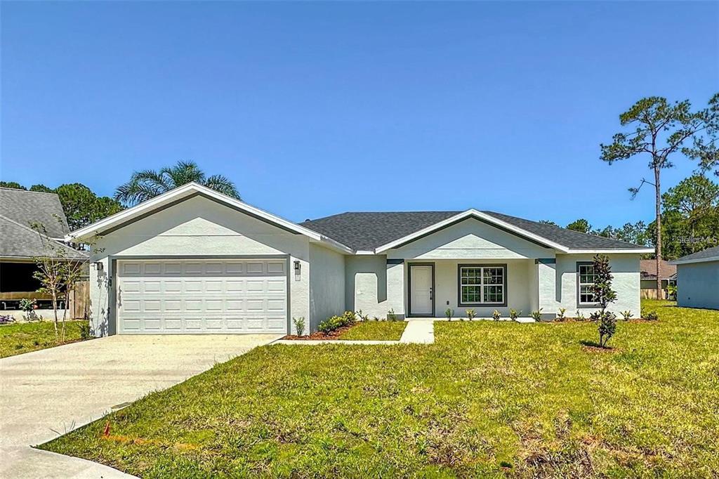 a front view of a house with a garden and yard