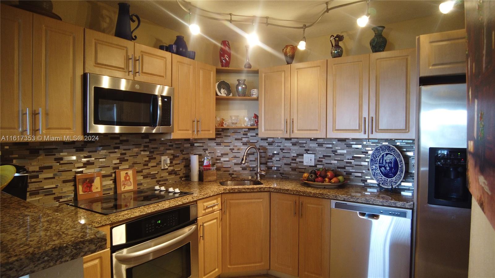 a kitchen with stainless steel appliances granite countertop a stove a sink and a microwave