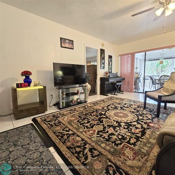 a living room with a rug and a flat screen tv