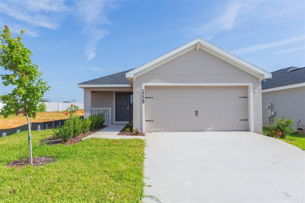 a front view of a house with a yard and garage