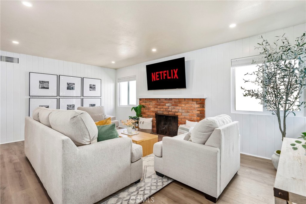 a living room with furniture a flat screen tv and a fireplace