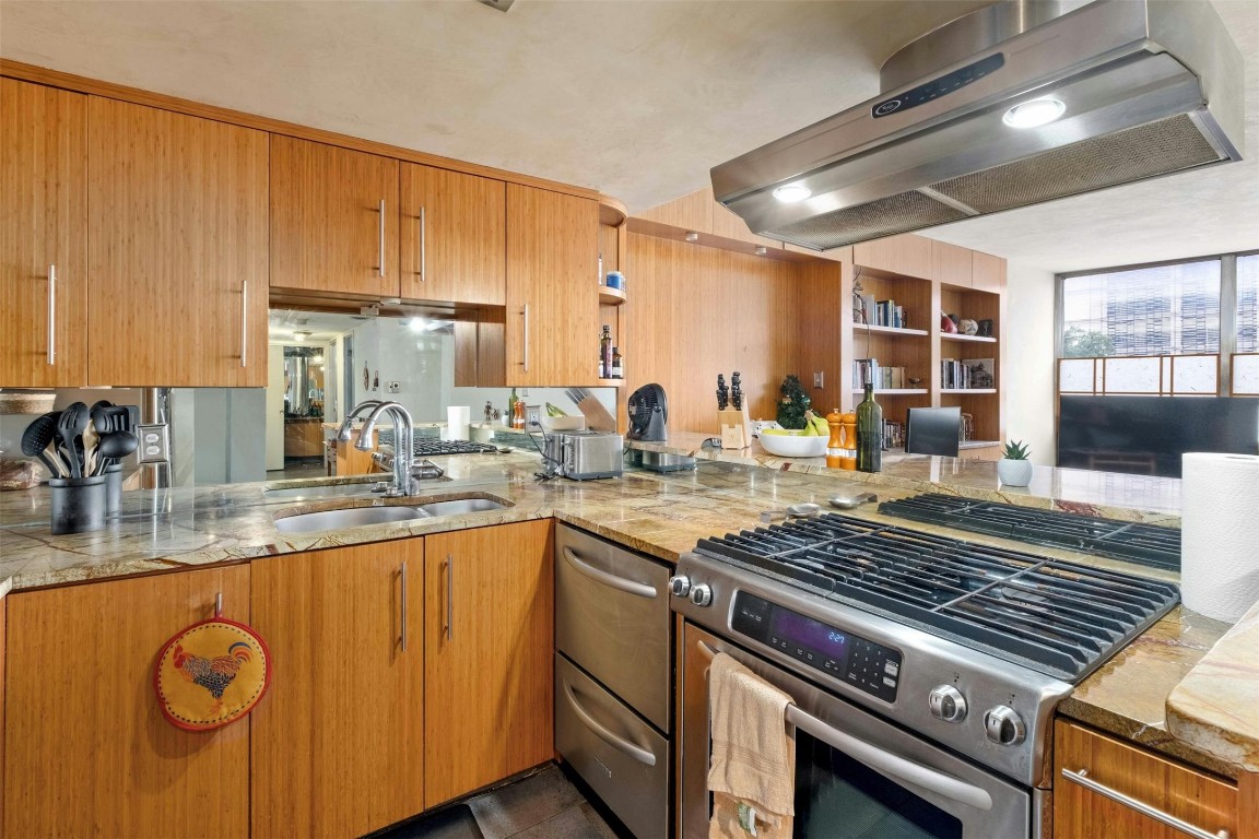 a kitchen with stainless steel appliances granite countertop a stove and a sink