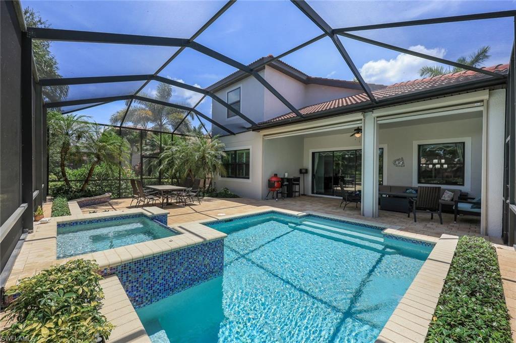 a view of a backyard with swimming pool table and chairs under an umbrella