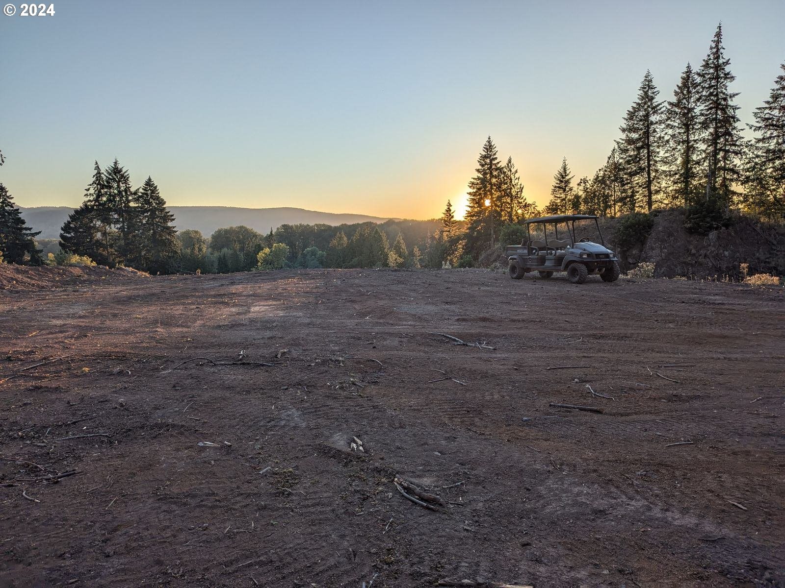 a view of dirt road with a building in the background