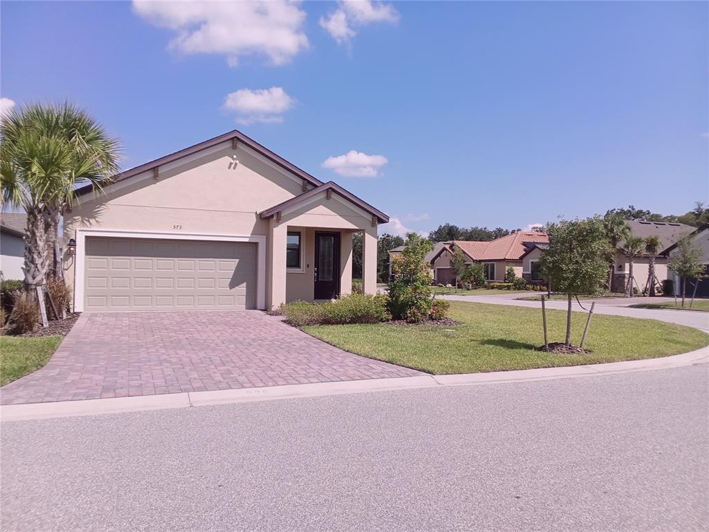 a front view of a house with a yard and garage