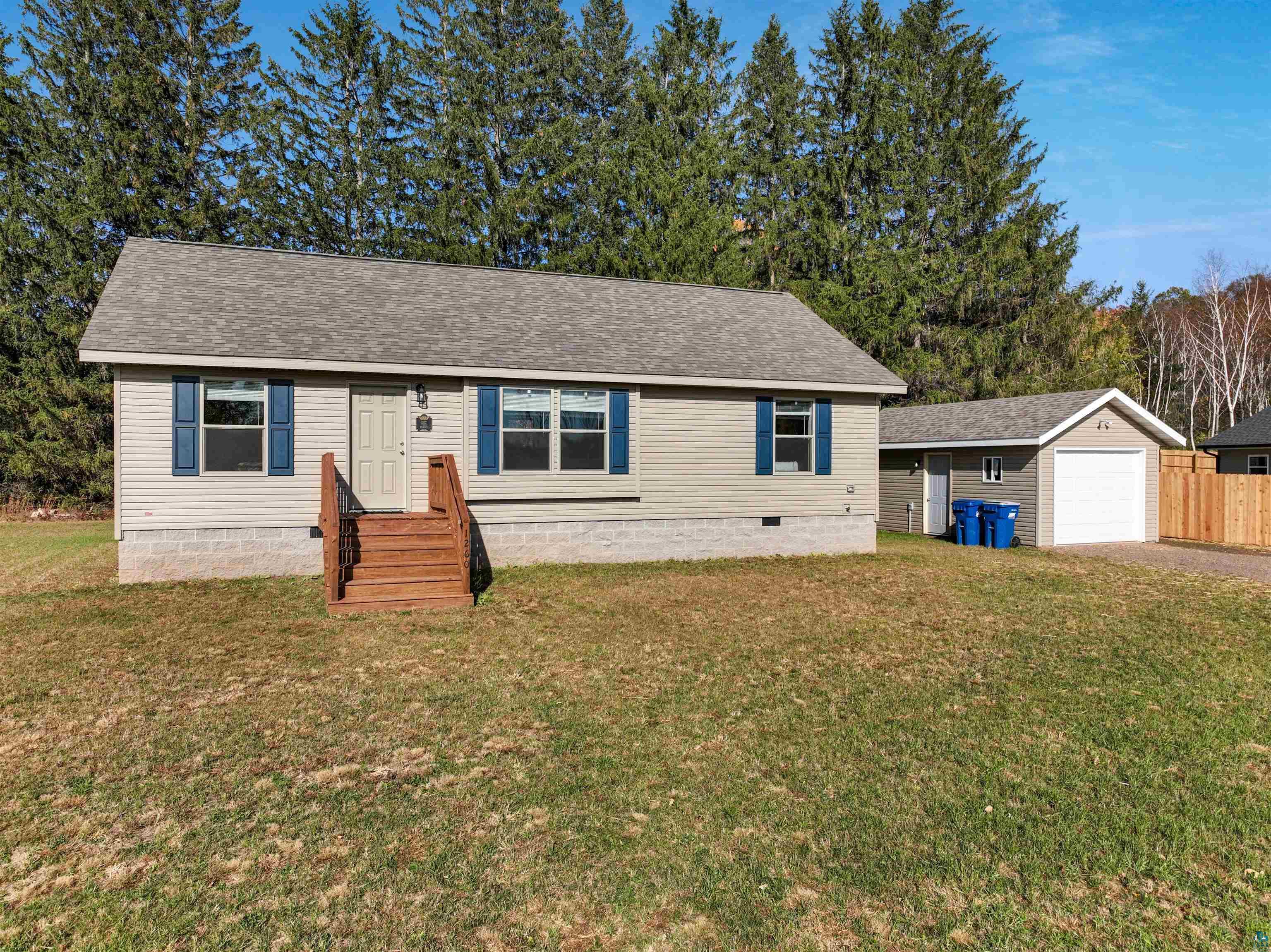 View of front of home featuring a front yard, an outdoor structure, and a garage