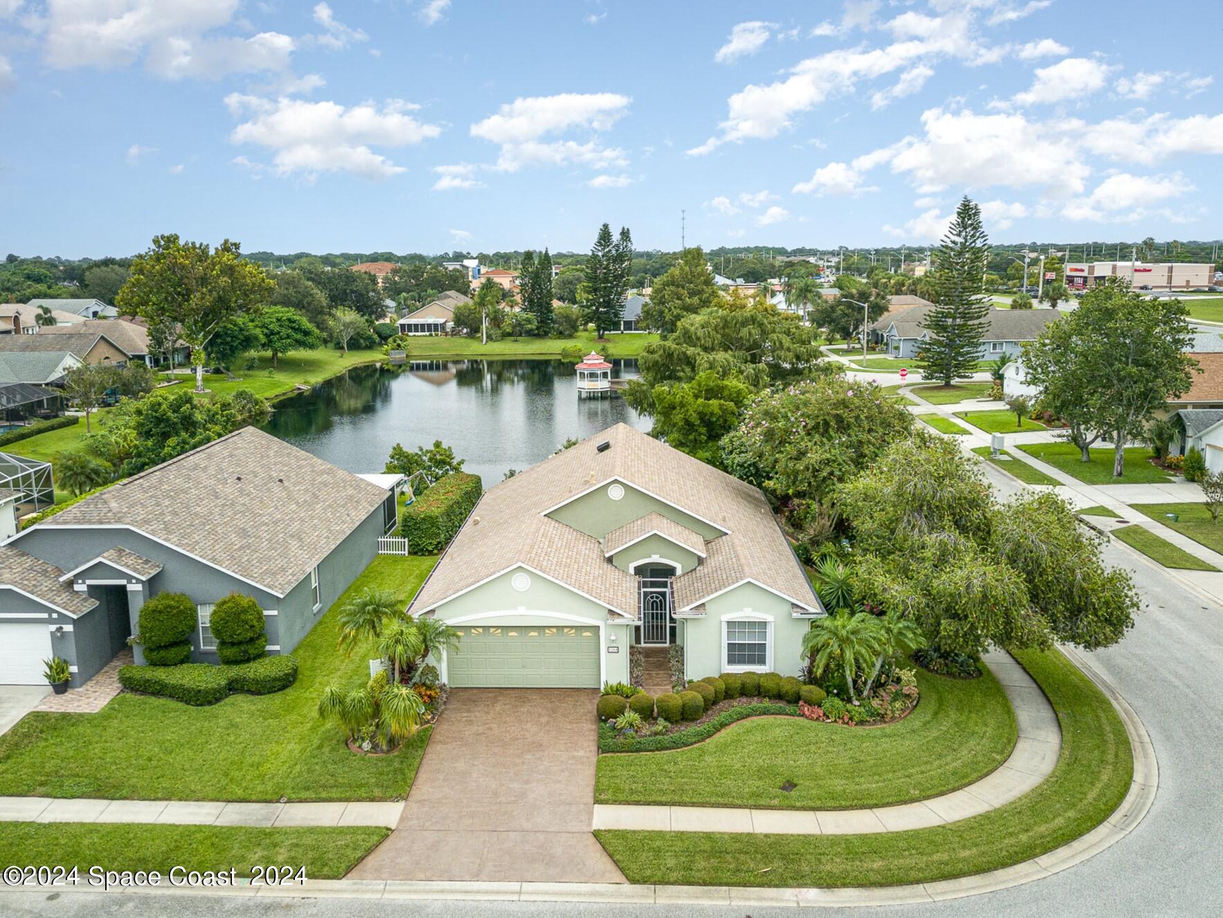 a view of a house with a yard and lake view