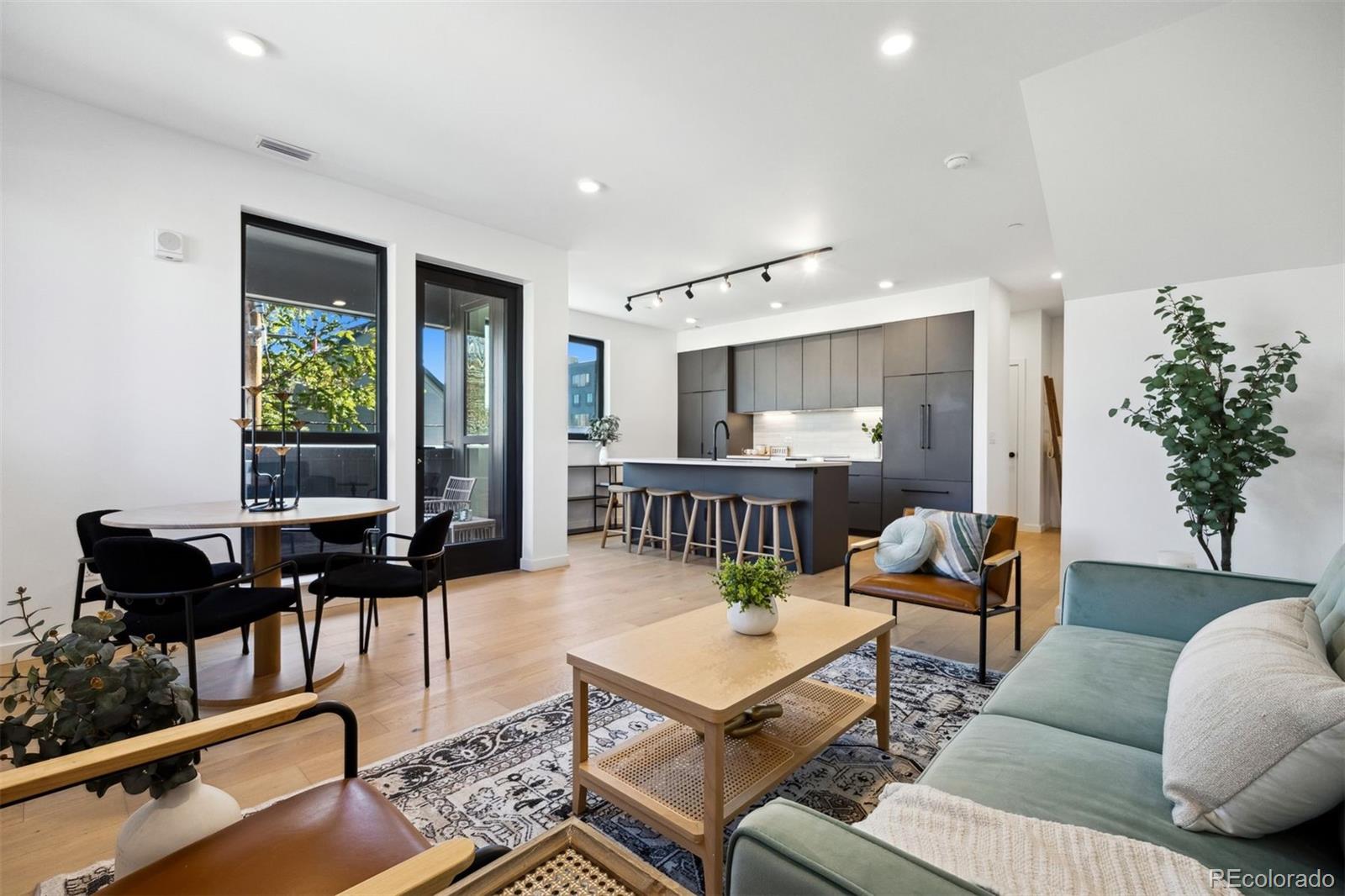 a living room with furniture kitchen view and a potted plant