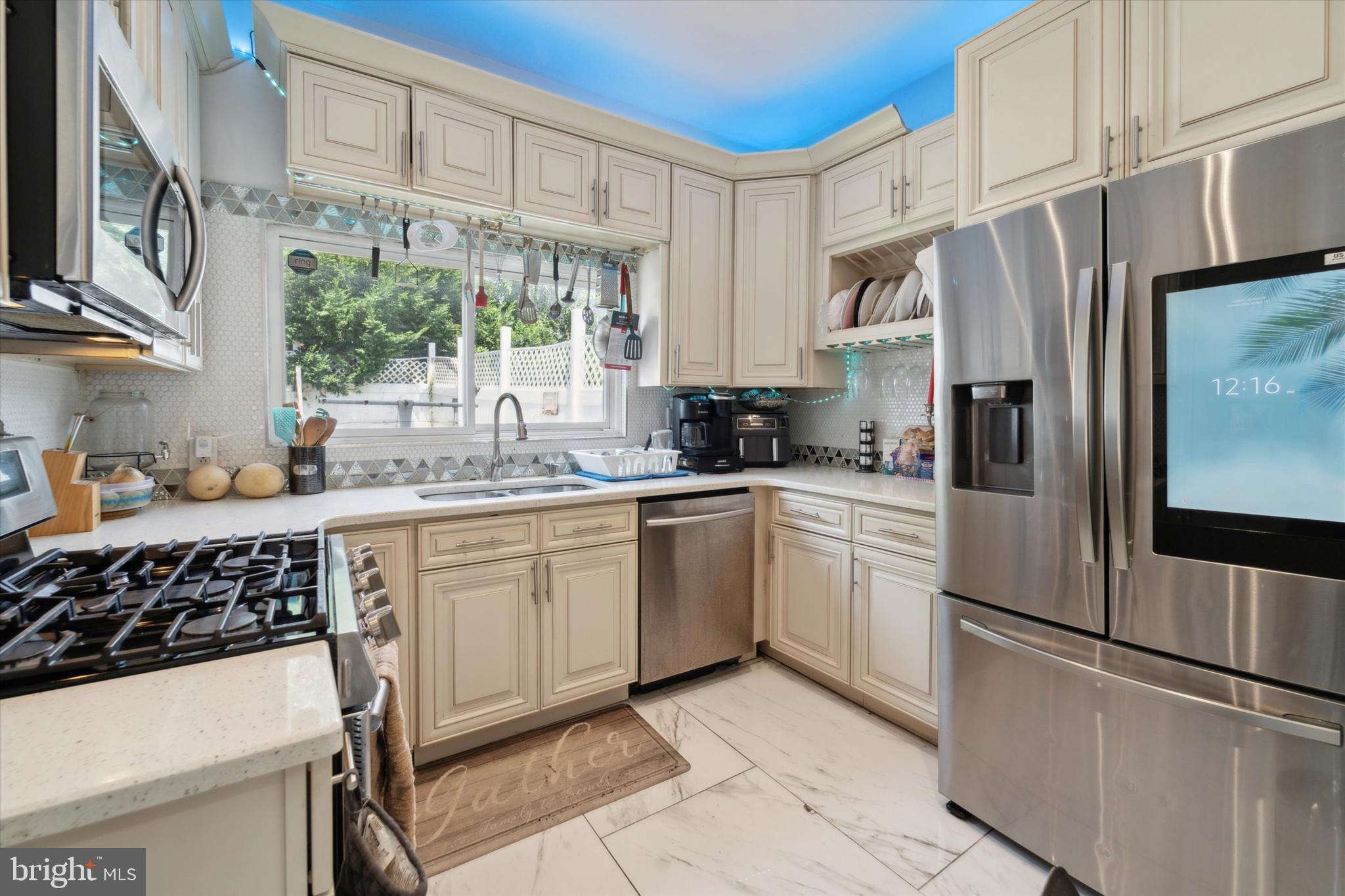 a kitchen with stainless steel appliances a refrigerator sink and cabinets