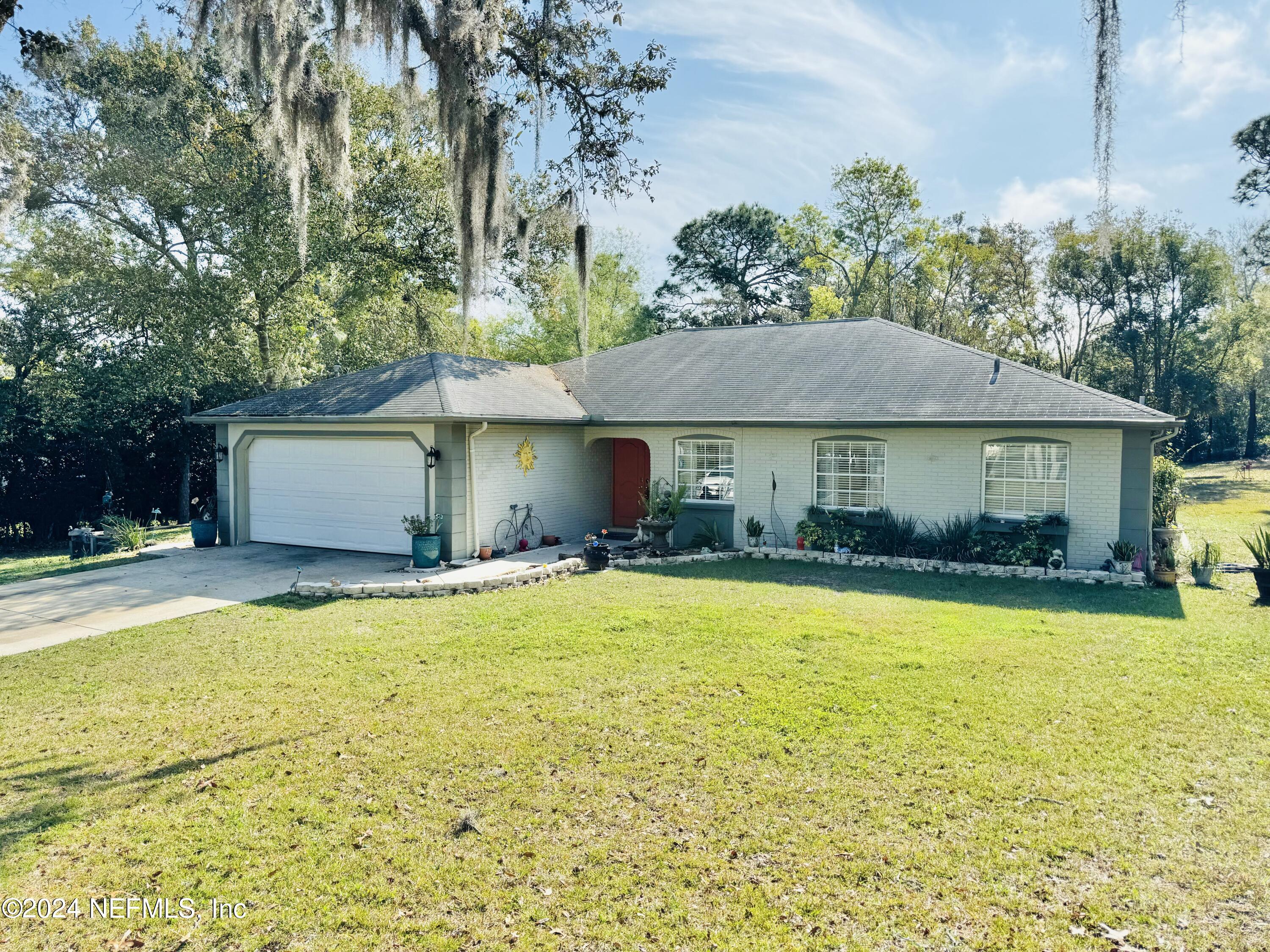 a front view of a house with a yard and trees