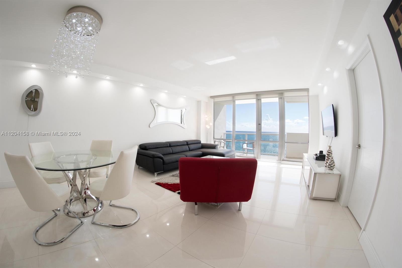 a living room with furniture a floor to ceiling window and wooden floor