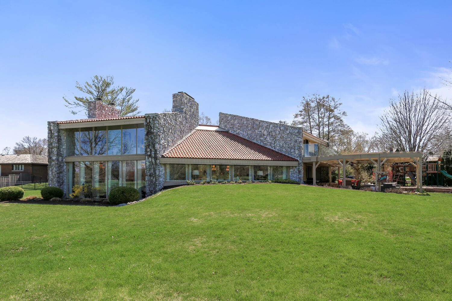 a view of a big house with a big yard and large trees