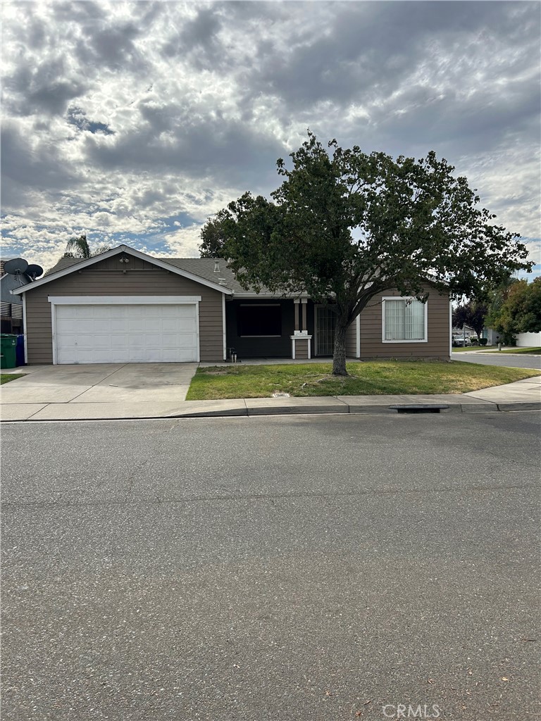 a view of a house with a yard and large trees