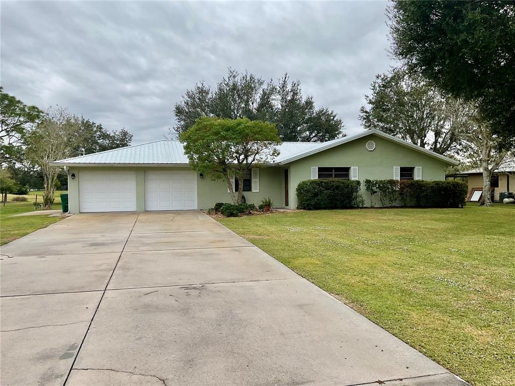 a front view of house with yard garage and green space