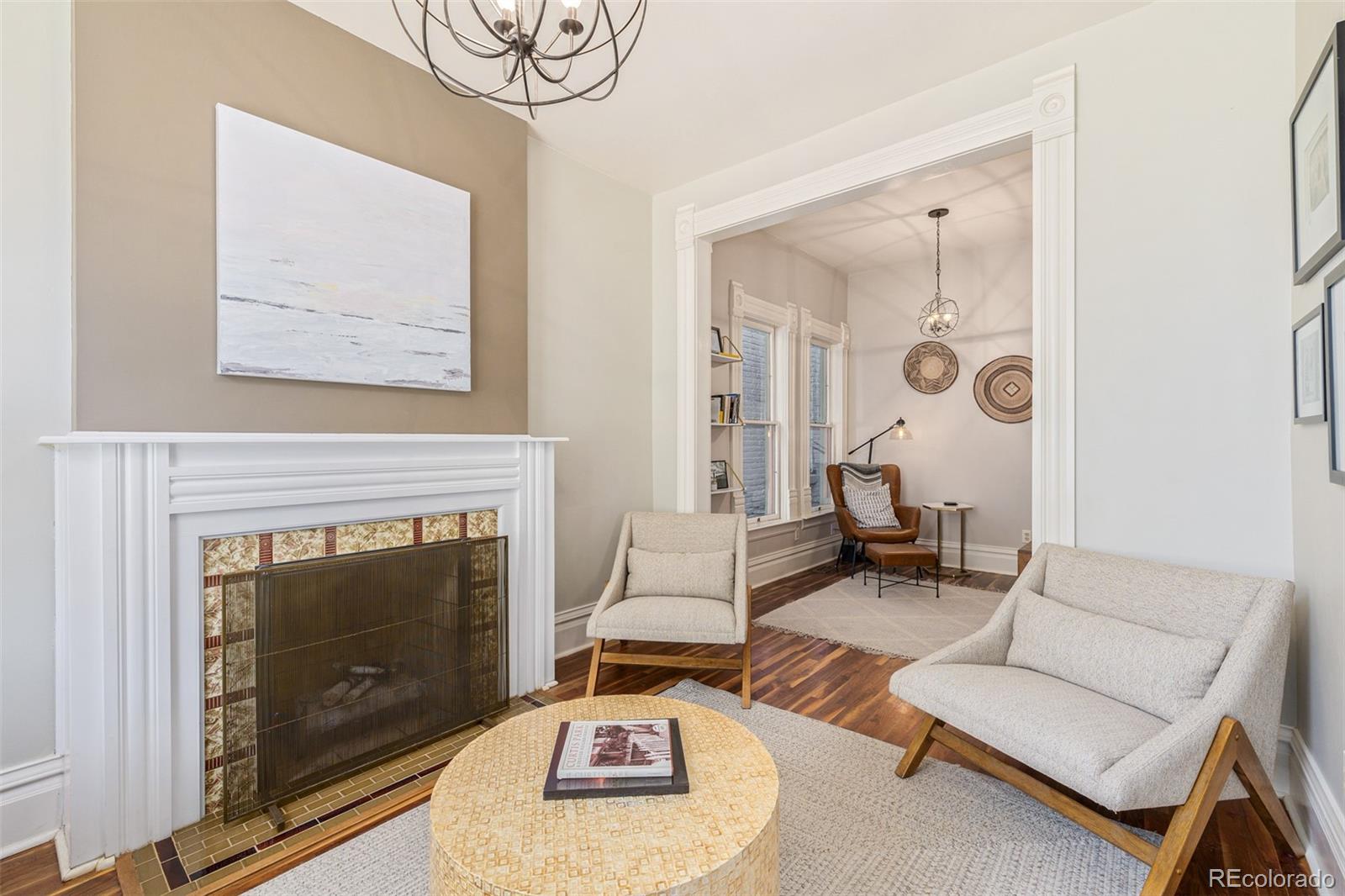 a living room with furniture a fireplace and a large mirror