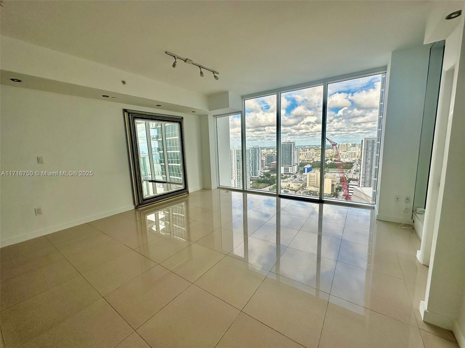 a view of an entryway with floor to ceiling window and an empty room