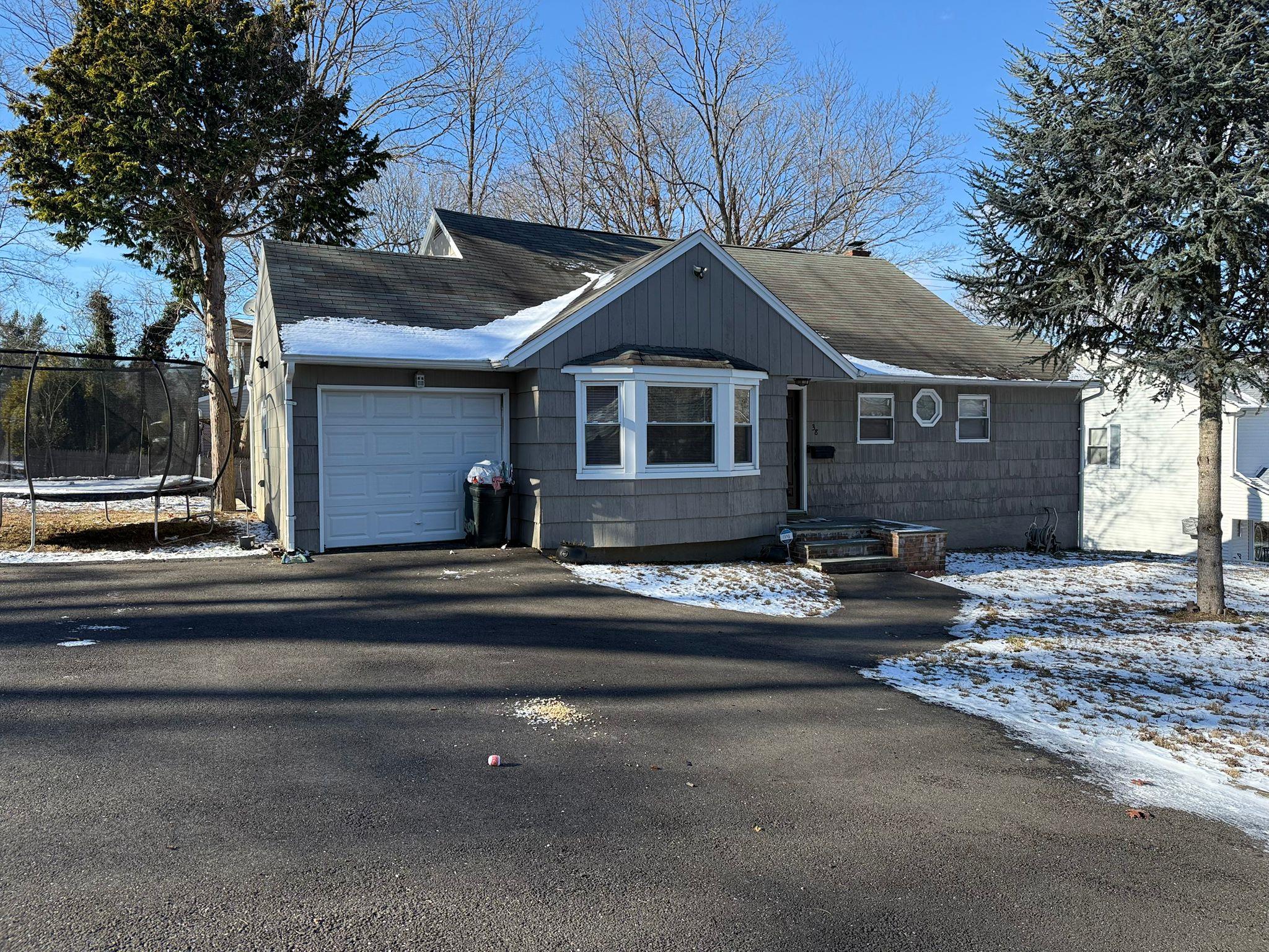 a front view of a house with yard and parking