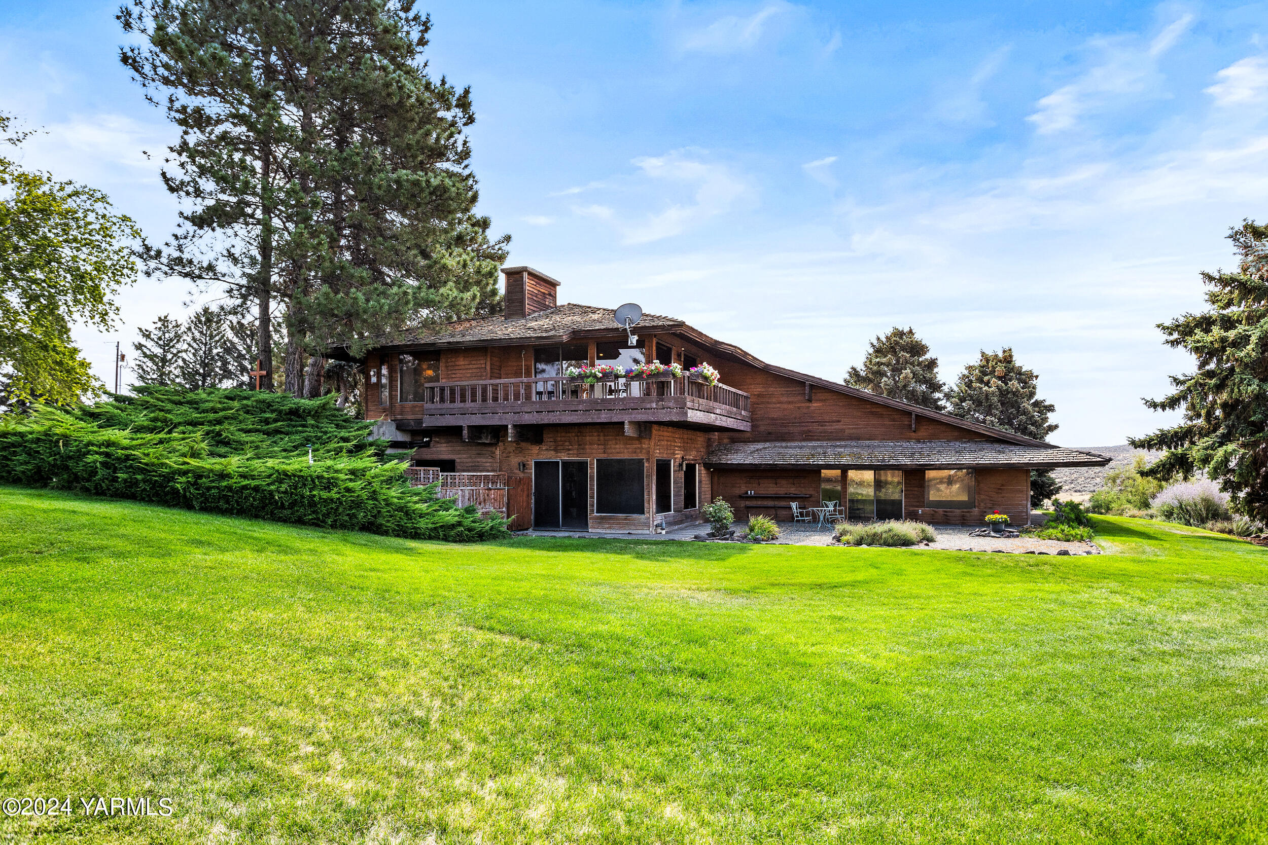 a view of a house with a big yard and large trees