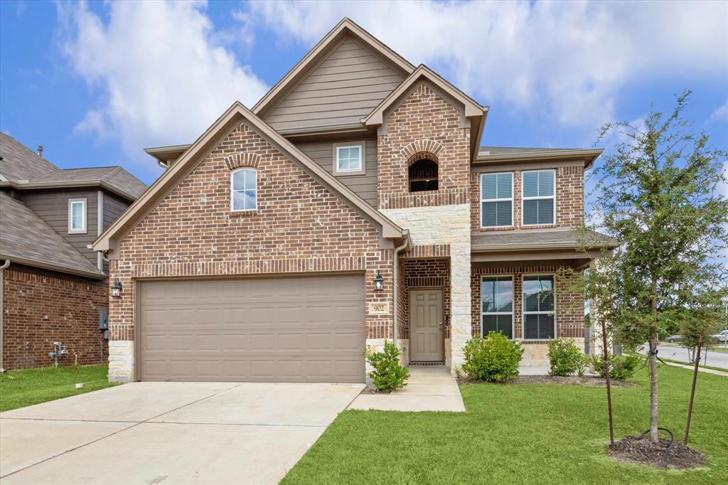 a front view of a house with a yard and garage