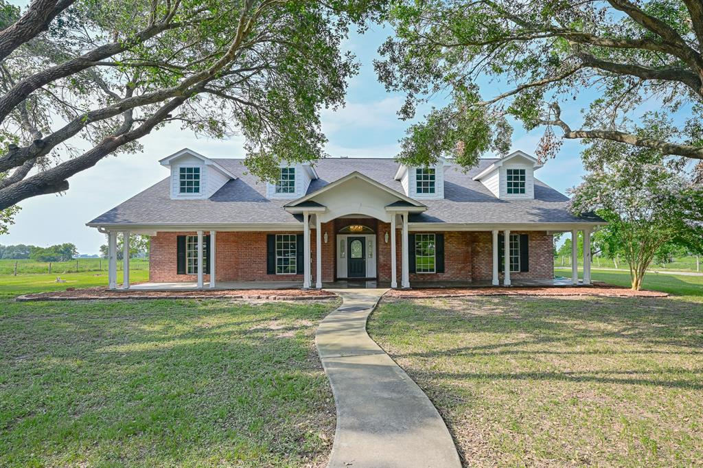 a front view of a house with a garden and trees