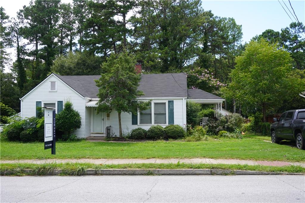 a front view of a house with a yard and potted plants