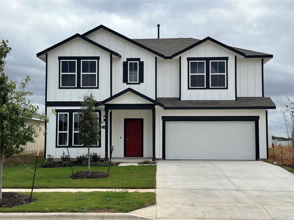 a front view of a house with a yard and garage