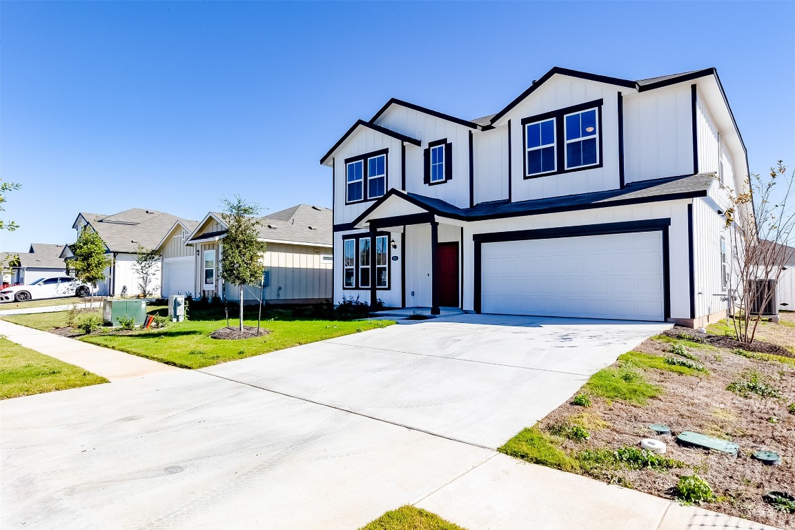 a front view of a house with a yard garage and outdoor seating